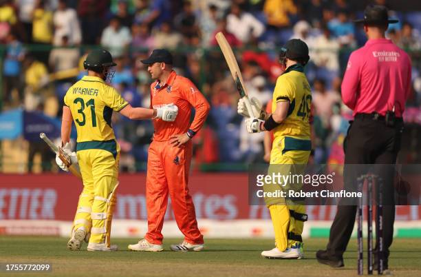 David Warner of Australia and Roelof van der Merwe of Netherlands interact during the ICC Men's Cricket World Cup India 2023 between Australia and...