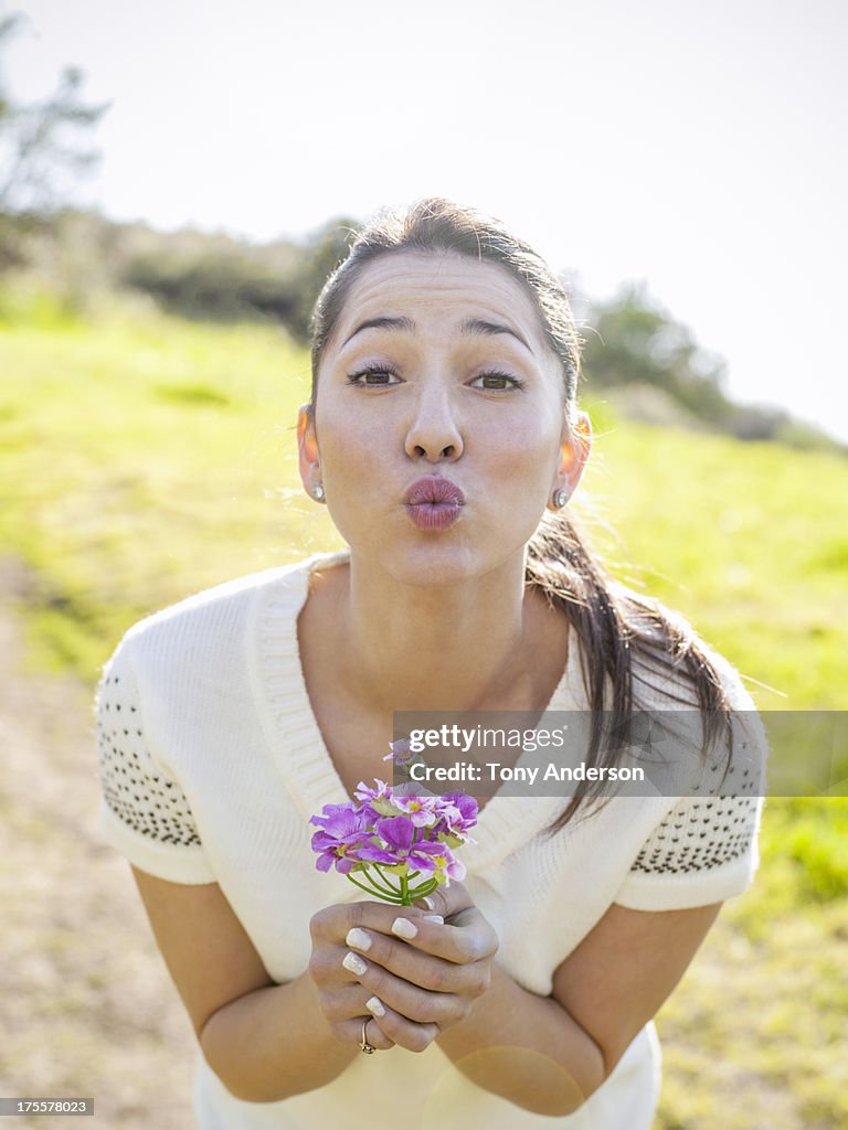 Young woman with flowers making kiss face