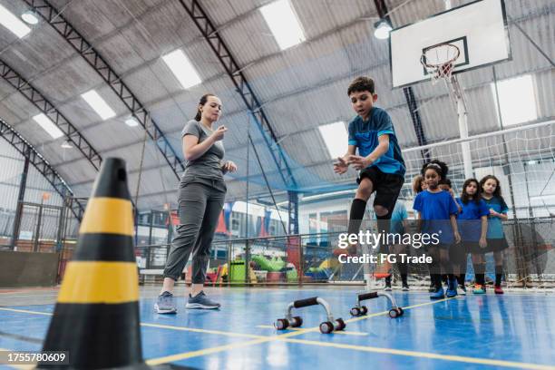 boy jumping in an agility training at a sports court - sports training camp stock pictures, royalty-free photos & images