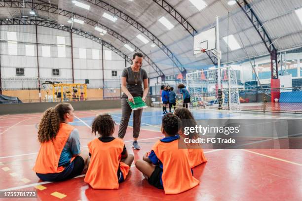 coach talking to team at a sports courts - volleyball sport stock pictures, royalty-free photos & images