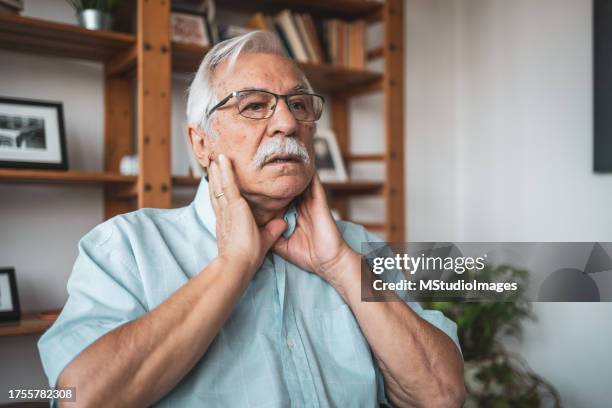 uomo anziano che sente dolore alla gola - tiroide foto e immagini stock