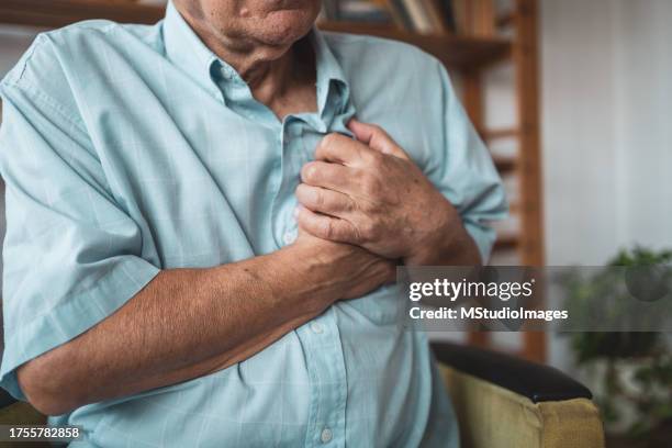 close-up of an elderly man's hand held his chest in pain - heart ventricle bildbanksfoton och bilder