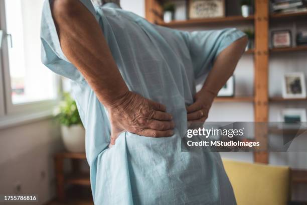nahaufnahme eines älteren mannes mit rückenschmerzen - knochenbruch stock-fotos und bilder