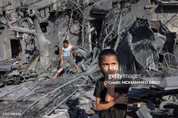 Girl looks on as she stands by the rubble outside a building that was hit by Israeli bombardment in Rafah in the southern Gaza Strip on October 31,...