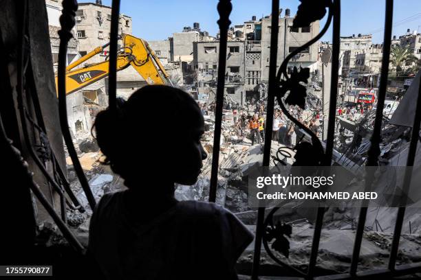 Girl stands behind the metal mesh that covered the window of a building that was hit by Israeli bombardment in Rafah in the southern Gaza Strip on...