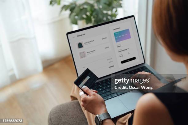 young woman doing online shopping via laptop and making payment with credit card - datos personales fotografías e imágenes de stock