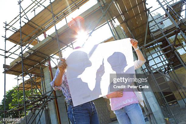 couple looking at plans on building site - building activity ストックフォトと画像