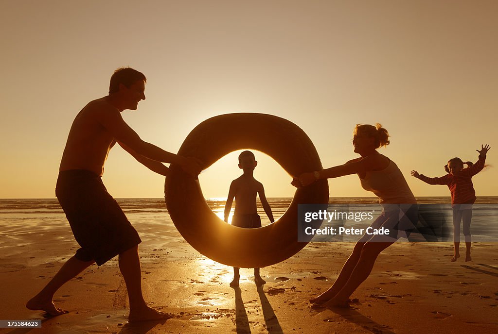 Family playing with rubber ring on beach