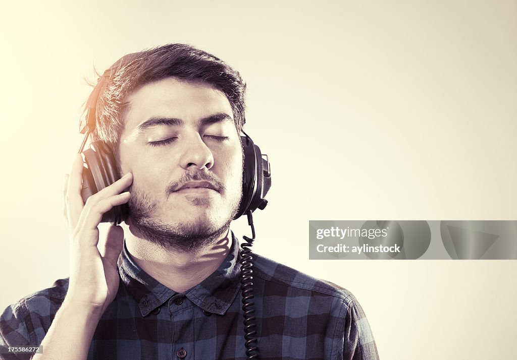 Young man enjoying music with eyes closed