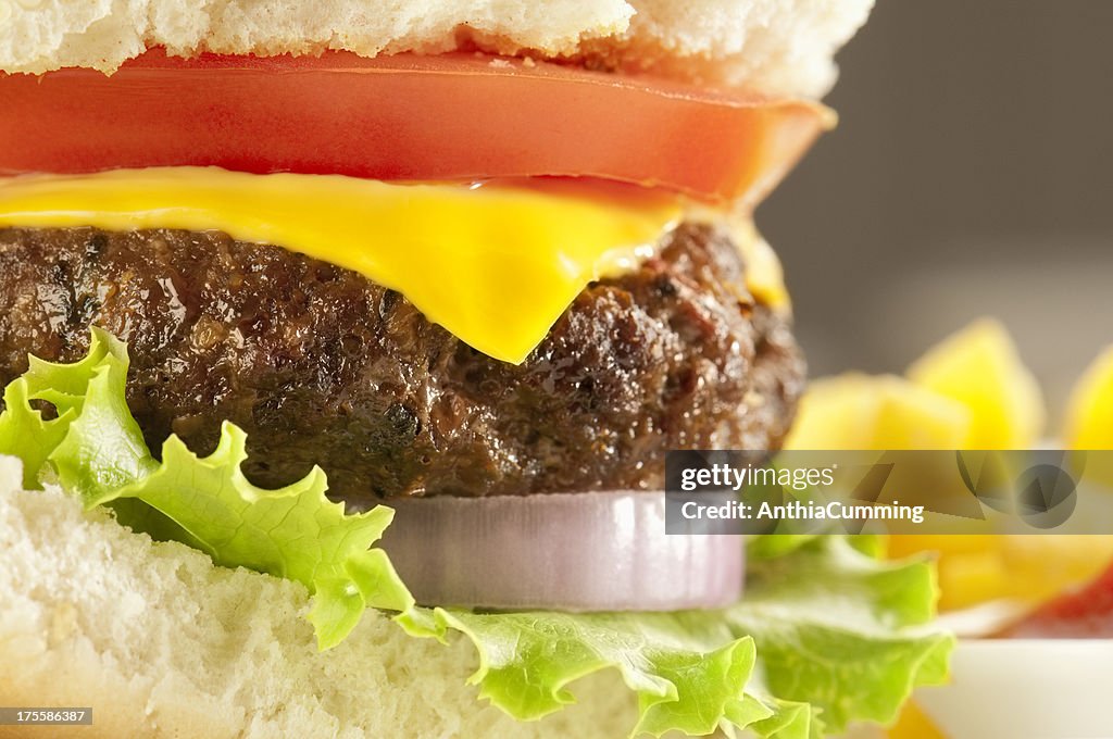 Cheeseburger with tomato, onion and lettuce in a white bap