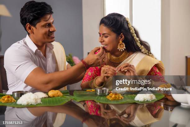 happy couple having onam sadhya together at home - onam stock pictures, royalty-free photos & images
