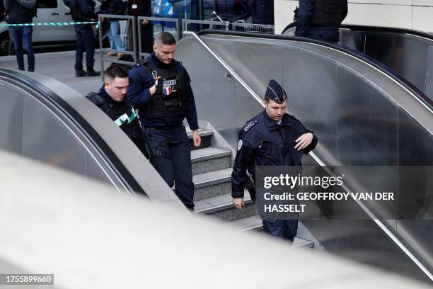 French police officers enter a metro station after a woman making threats on an RER train was shot and wounded by police, at the Bibliotheque...