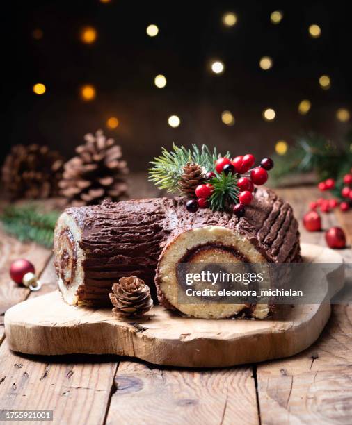 close-up of a christmas chocolate yule log (buche de noel) on a wooden chopping board - christmas log stock-fotos und bilder