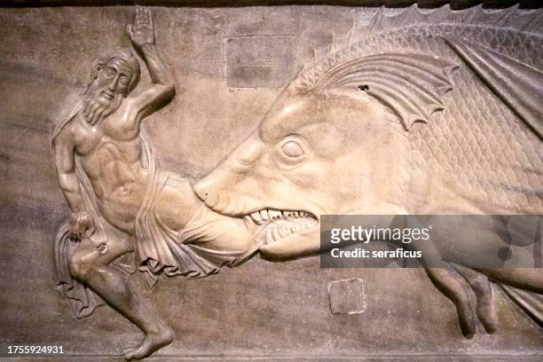 jonah and the whale, in a medieval bas relief in the cathedral of sessa aurunca, in campania, italy - relief bildbanksfoton och bilder