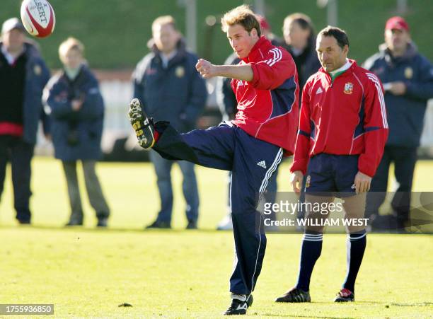 Britain's Prince William kicks the ball while assistant coach Dave Alred looks on as he takes some lessons from British and Irish Lions flyhalf...