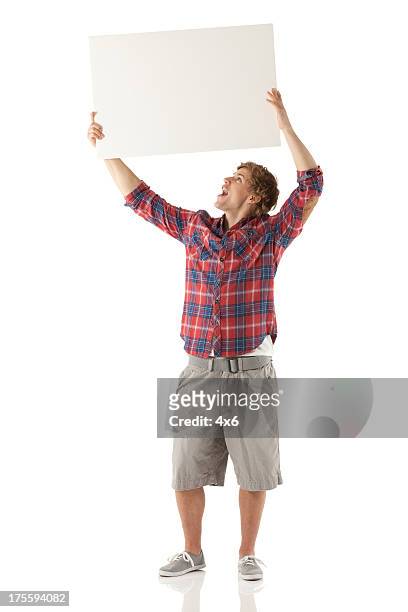 man holding up a placard - placard stockfoto's en -beelden