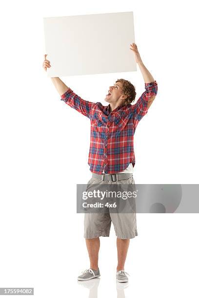 man holding up a placard - plakkaat stockfoto's en -beelden