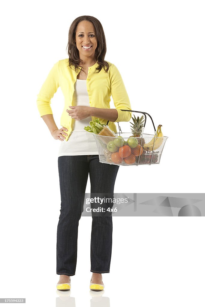 Happy woman holding a basket of fruits