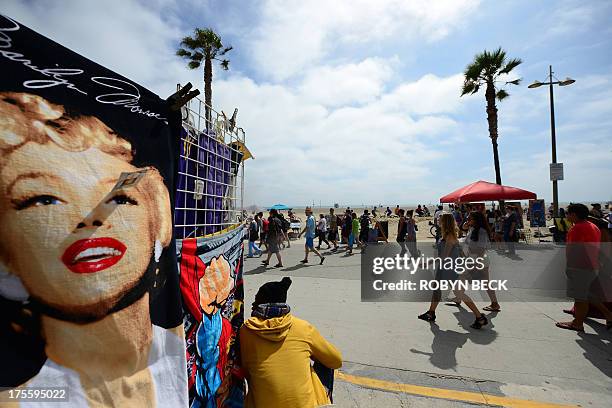 People walk on the Venice Beach boardwalk on August 4, 2013. One day earlier, 32-year-old Italian newlywed Alice Gruppioni was killed after a man...