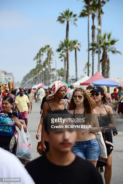 People walk on the Venice Beach boardwalk on August 4, 2013. One day earlier, Italian newlywed Alice Gruppioni was killed after a man slammed his car...