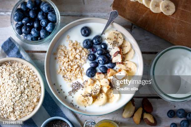blueberries, banana slices, oat flakes and yoghurt - yoghurt stock pictures, royalty-free photos & images