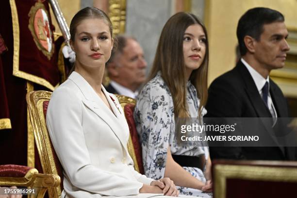 Spanish Crown Princess of Asturias Leonor looks on next to Spanish Princess Sofia and Spain's Prime Minister Pedro Sanchez as she attends a ceremony...