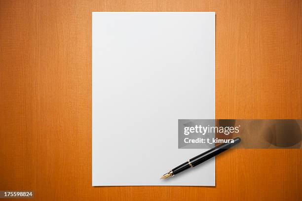 blank paper on desk with a pen - vulpen stockfoto's en -beelden