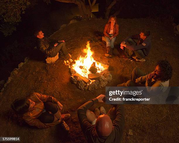 campfire of friends in circle on the fire - campfire storytelling stock pictures, royalty-free photos & images