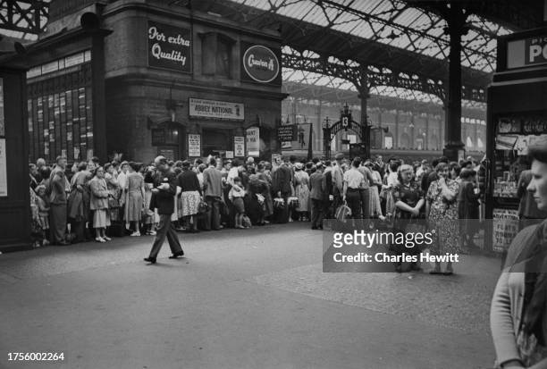 Crowd of people looking to take advantage of the good weather during the heatwave on the Whit Monday holiday, queuing at Victoria Station, London,...