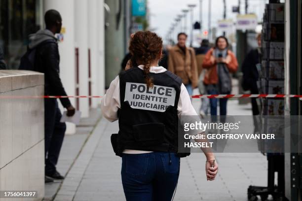 French police officer wears a jacket, identifying herself as "Police identite judiciaire"), while walking from a metro station after a woman making...