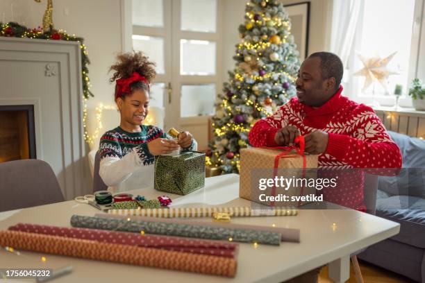father and daughter wrapping christmas gifts - decorating the christmas tree stock pictures, royalty-free photos & images