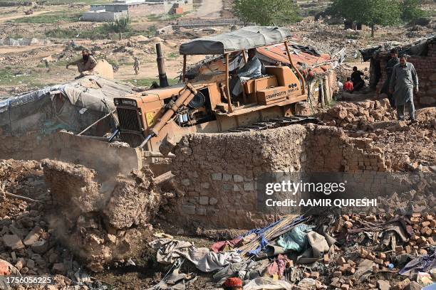 Bulldozer is being used to demolish houses of Afghan refugees, during an operation by local authorities at a refugee camp in Islamabad on October 31,...