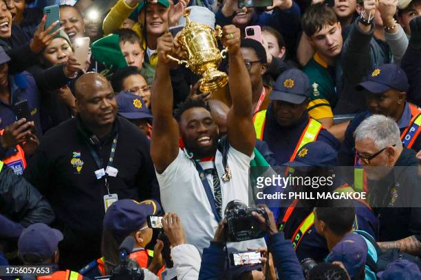 South Africa's flanker and captain Siya Kolisi holds the Webb Ellis Cup as he meets with supporters after the South African rugby team's arrival at...