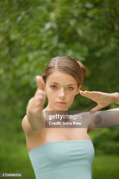 young woman doing tai chi - female martial arts stock pictures, royalty-free photos & images