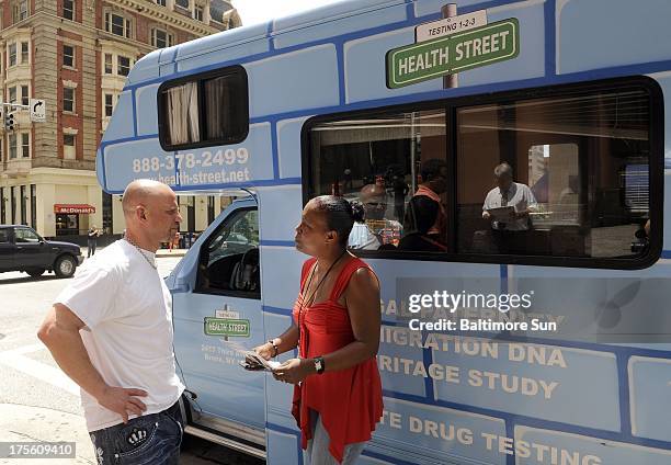 Jared Rosenthal, left, owner of the "Who's Your Daddy?" DNA testing truck, answers questions from Calore West, who works as a program coordinator for...