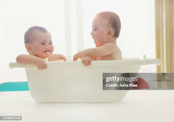 baby twins having a bath - female twins stock pictures, royalty-free photos & images