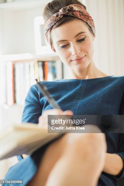 woman writing on notebook - girlie room stock pictures, royalty-free photos & images