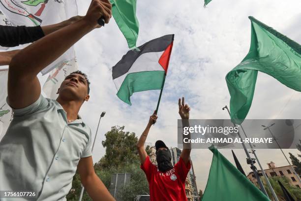 People lift flags during a rally near the French Embassy in Beirut, on October 31 in support of Palestinians in Gaza amid the ongoing conflict...