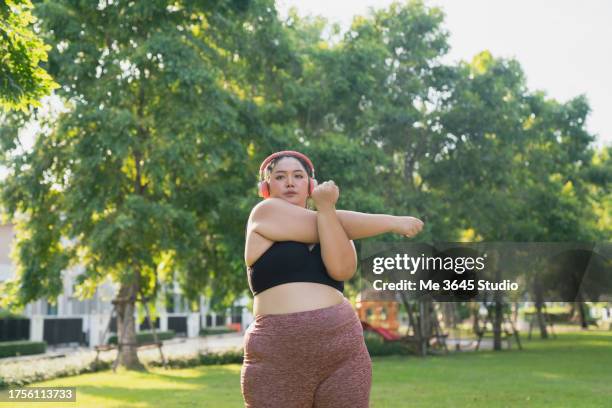 young female asian stretching and relaxing  at village park home. - after workout stock pictures, royalty-free photos & images