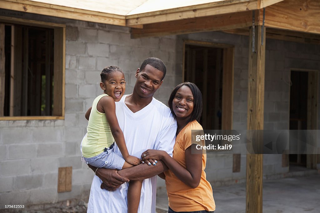 Família na frente de casa em construção