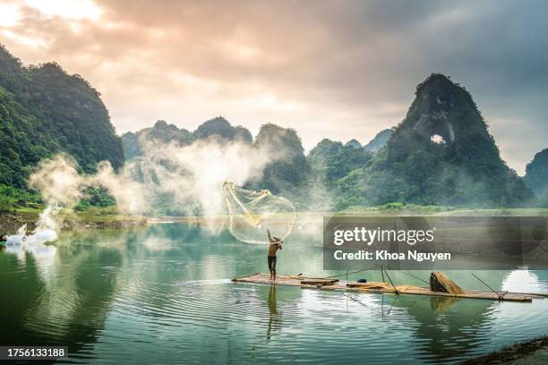 view of fishermen fishing on river in thung mountain in tra linh, cao bang province, vietnam with lake, cloudy, nature - vietnam stockfoto's en -beelden