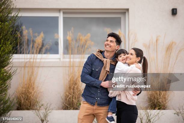 happy young family looking at their new home - dreaming of home ownership stock pictures, royalty-free photos & images