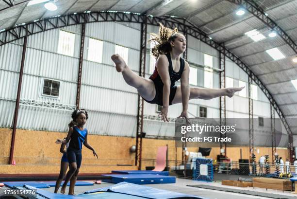 girl jumping in a gymnasium - turnen stockfoto's en -beelden