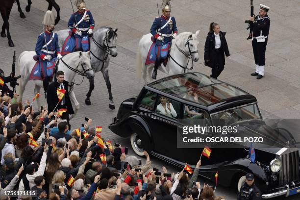 Spanish Crown Princess of Asturias Leonor waves to the crowd from her car as she leaves after attending a ceremony to swear loyalty to the...