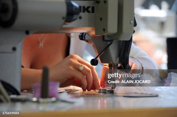 An employee of the "Indiscrete" lingerie brand uses a sewing machine on July 1, 2013 at the company's production site in Chauvigny, centralwestern...