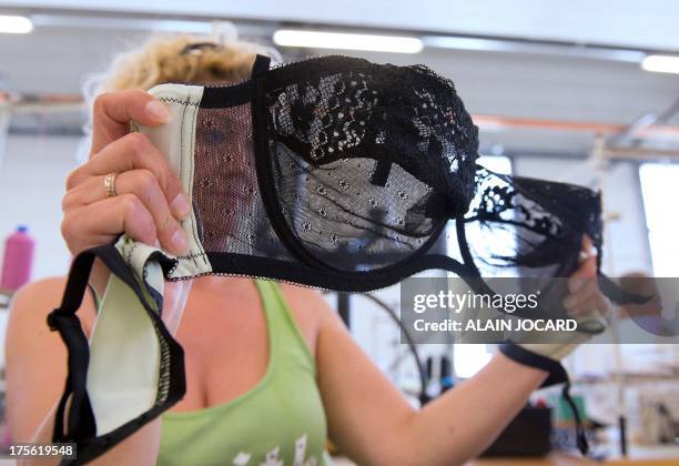 An employee of the "Indiscrete" lingerie brand checks a bra on July 1, 2013 at the company's production site in Chauvigny, centralwestern France. The...