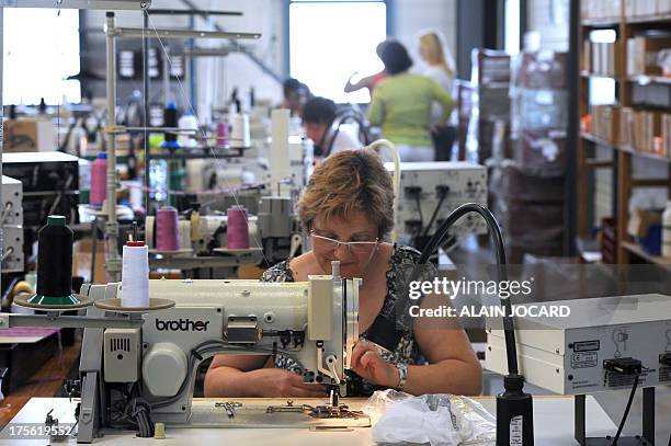 An employee of the "Indiscrete" lingerie brand manufactures a bra with a sewing machine on July 1, 2013 at the company's production site in...