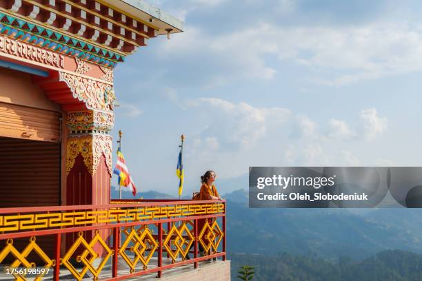 woman standing on the balcony of tibetan monastery - gompa stockfoto's en -beelden