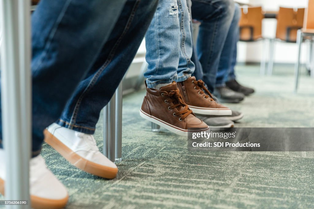Unrecognizable people sit in the lobby waiting to be seen