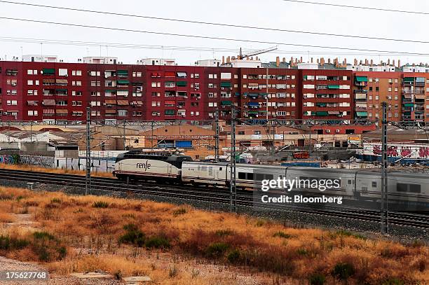 Train operated by Renfe Operadora SC passes a block of residential appartments as it arrives at Joaquin Sorolla trainstation in Valencia, Spain on...